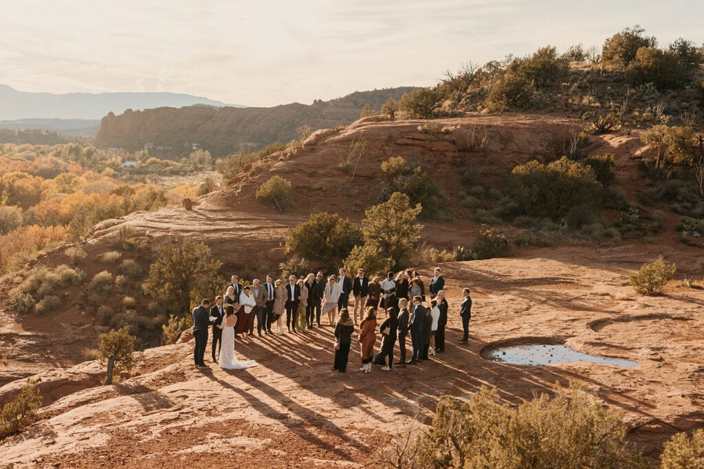 Guests stand on both sides of the bride and groom for their wedding Ceremony in Sedona Arizona