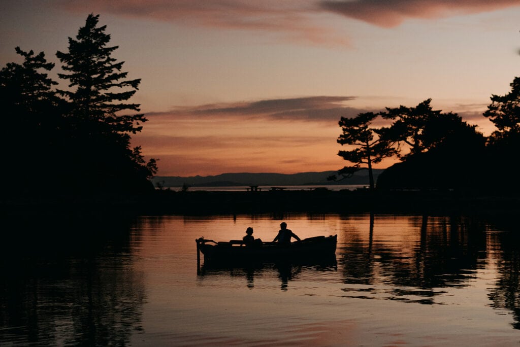 A couple sits in their boat at sunset after getting married on Sucia Island.