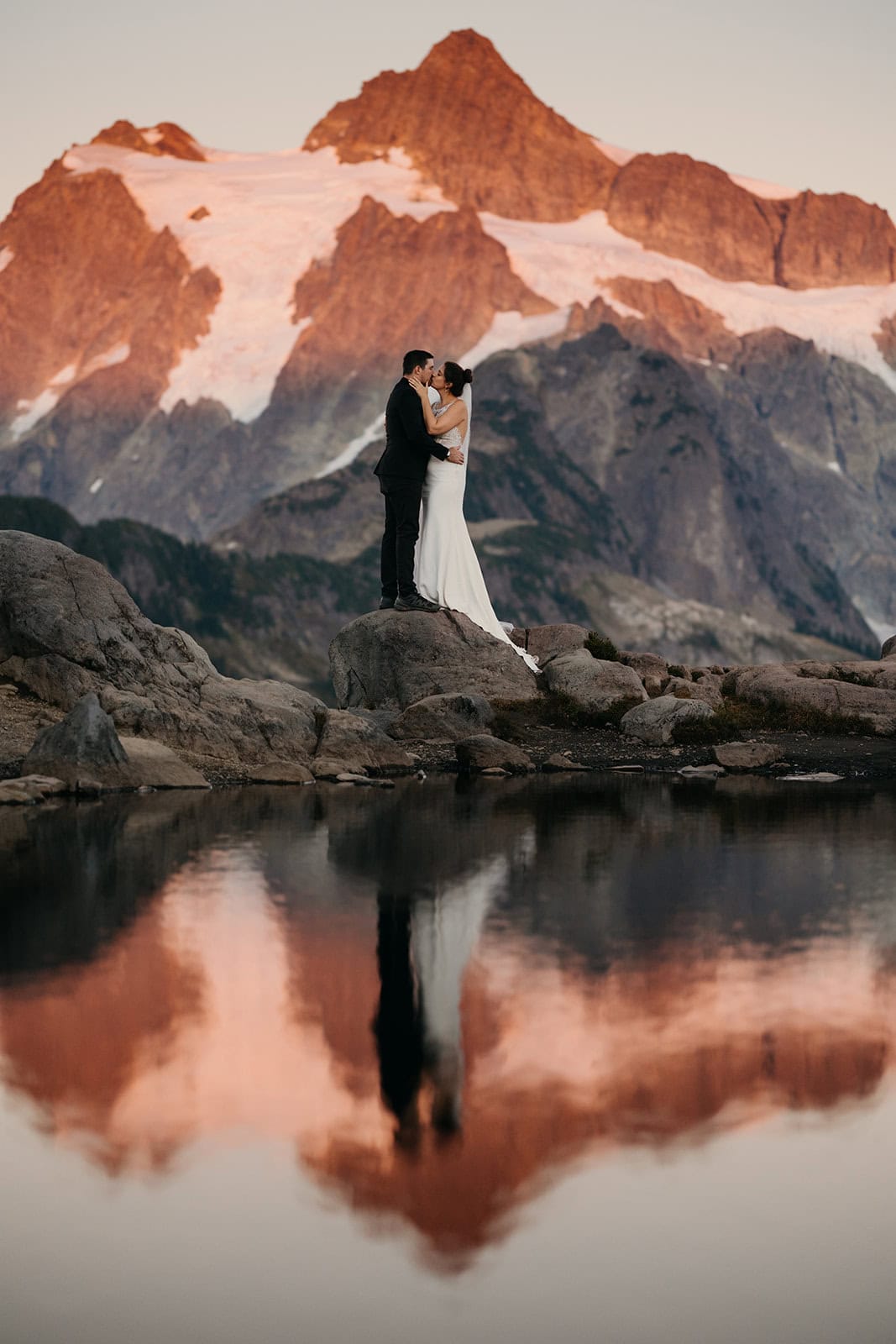 A couple shares a romantic moment during apline glow in the mountains of Washington.