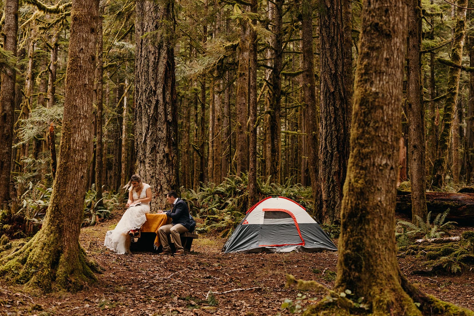 A couple writes their vows at their campsite.