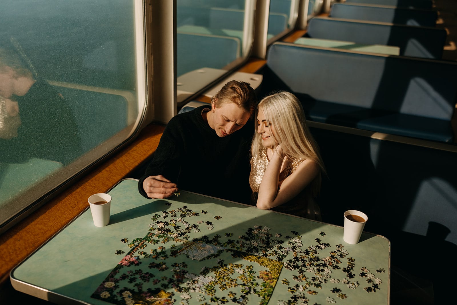 A couple enjoys coffee and a puzzle while riding the WA ferry.
