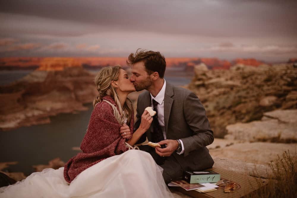 A bride and groom share a kiss at a vista looking down on Lake Powell.