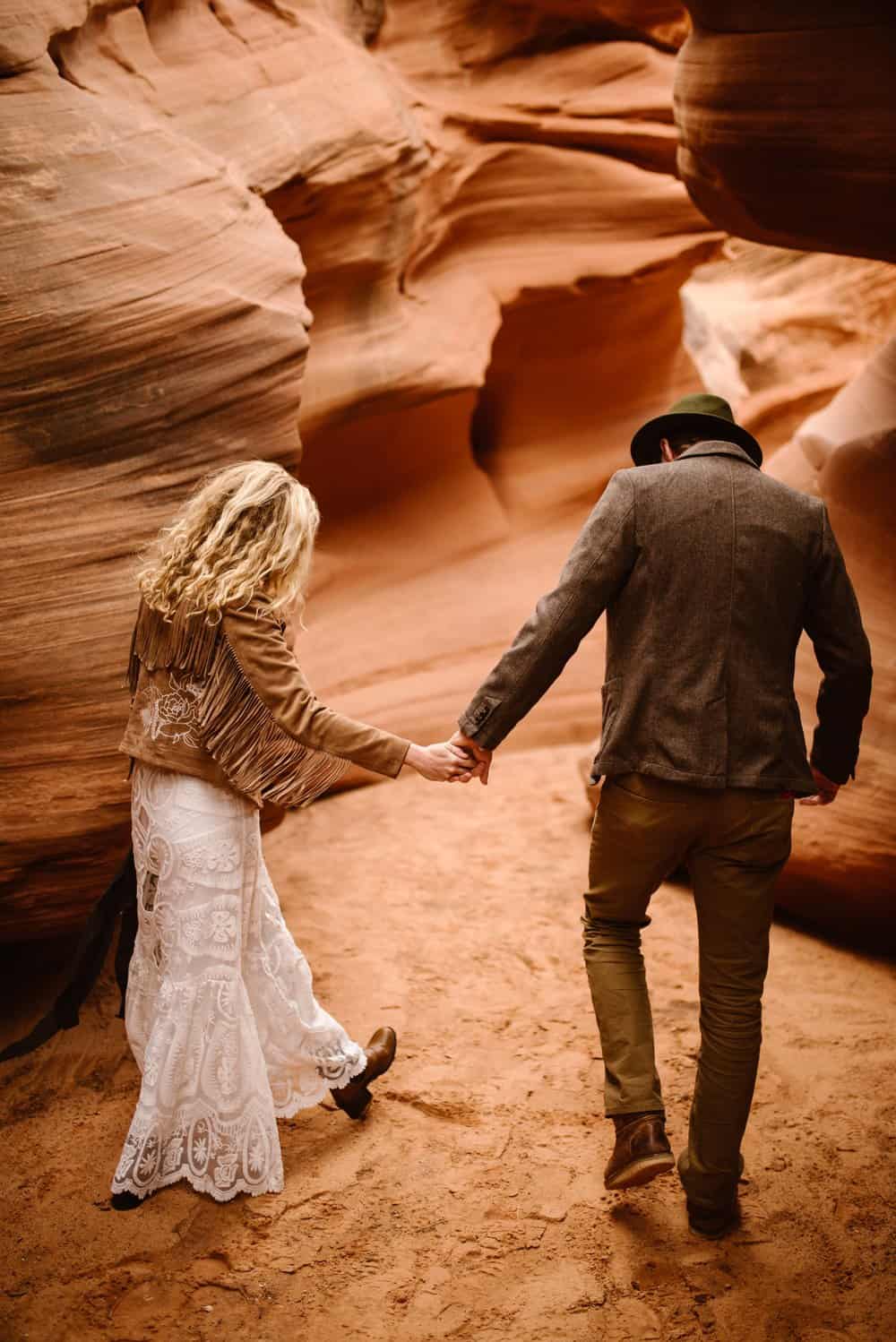A couple walks through a slot canyon together. 
