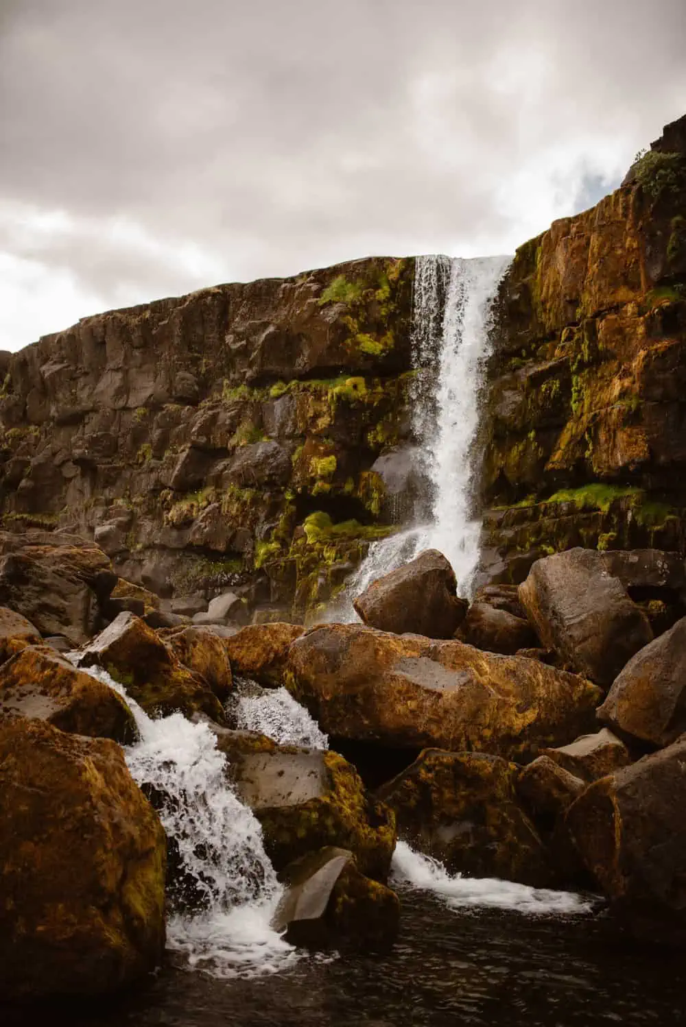 An icelandic waterfall going over rocks. 