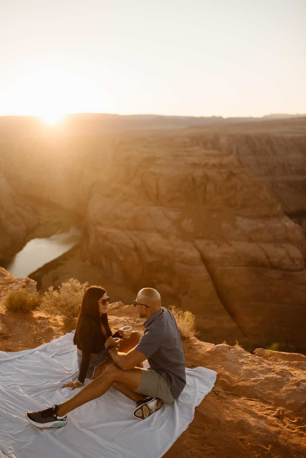 A couple shares a picnic after getting engaged at Horseshoe Bend.