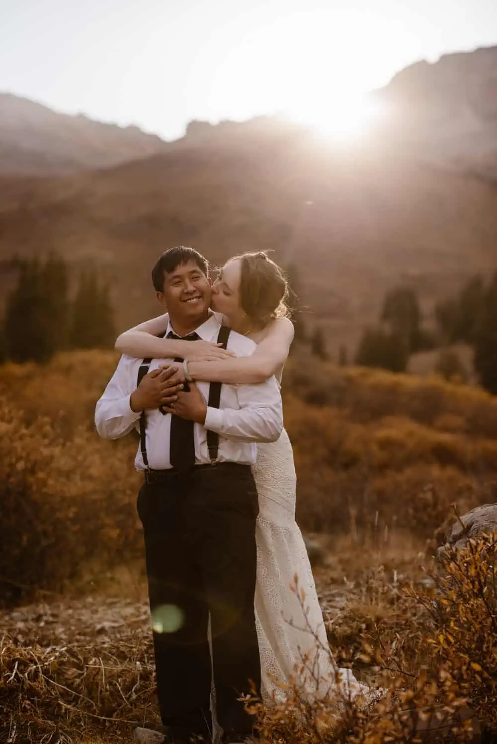 A bride kisses her groom in the mountains of Colorado.