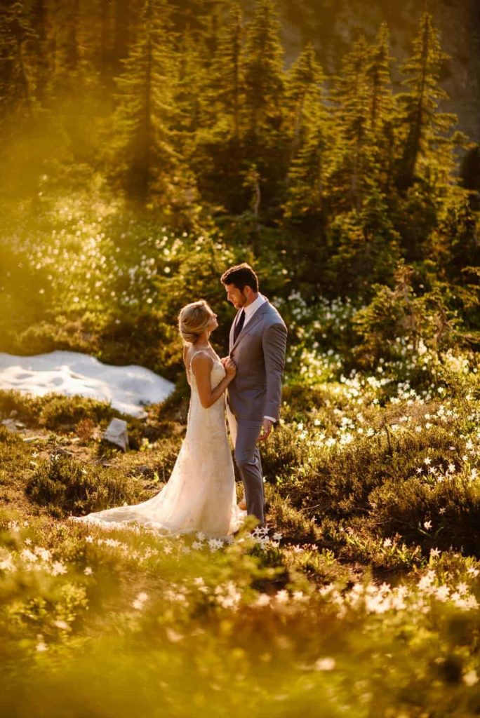 A couple stands on a trail surrounded by wildflowers as they elope in Washington.