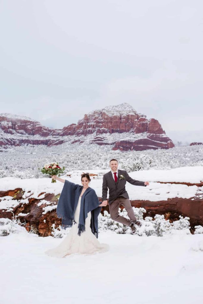 A couple just and smiles in the snow on a winter day in Sedona. 