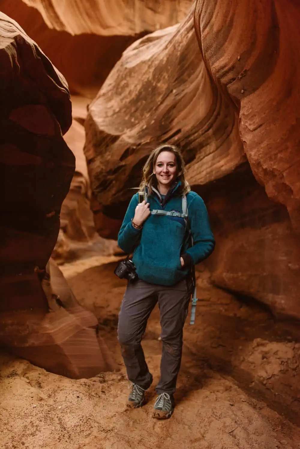 A portrait of a photographer standing in a slot canyon. 