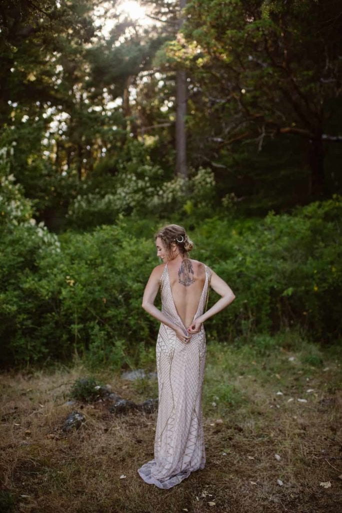 A bride zips up her dress. 