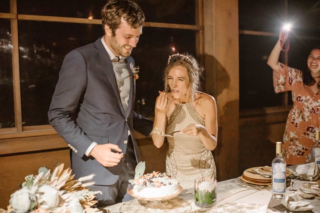 A bride and groom eating cake together on their wedding night.