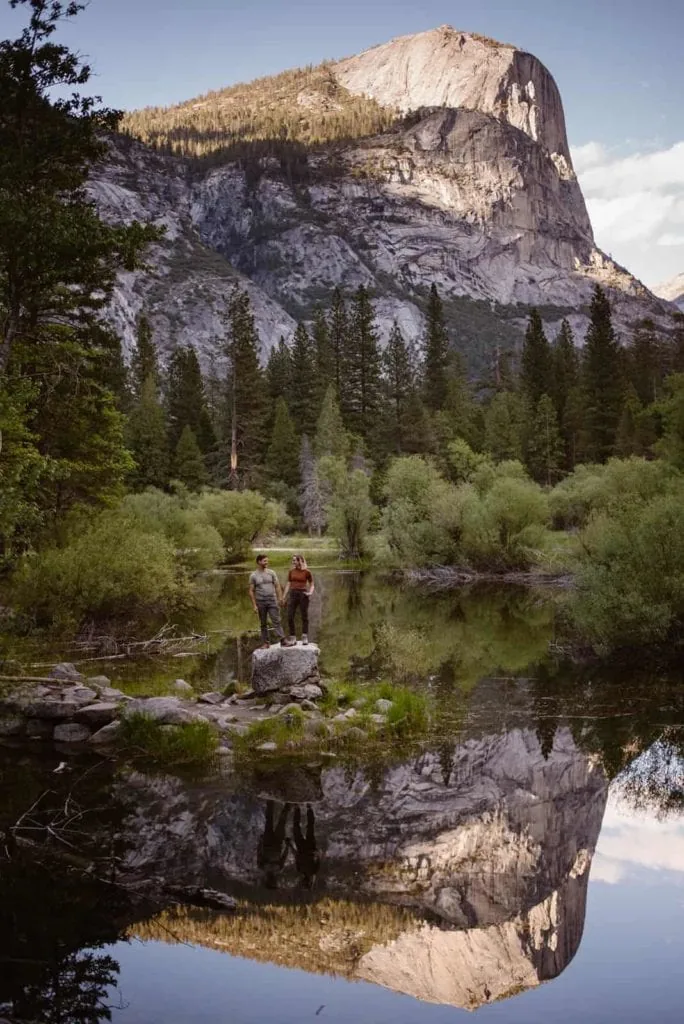 An elopement photography team stand for a portrait near a lake in Yosemite.
