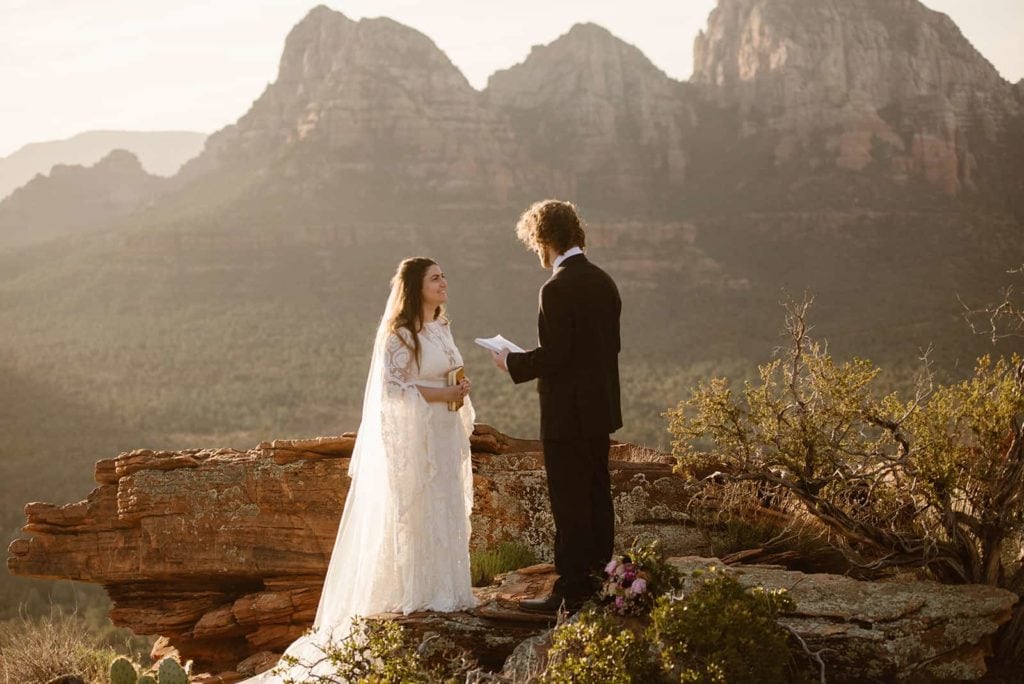 The bride and groom share their vows together as the sun just made its way up over the red rocks of Sedona.