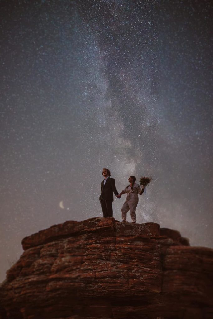 The bride and groom stand together for a milky way star photo on their hike to their elopement ceremony in Sedona.