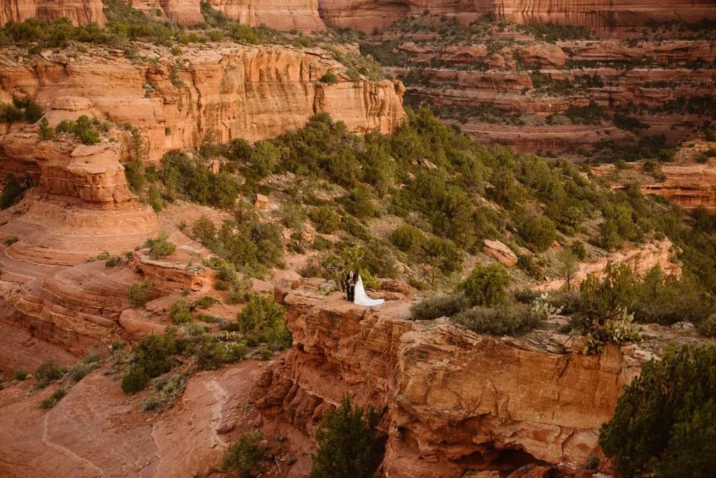 A bride and groom stand together in the beautiful red rocks of Sedona