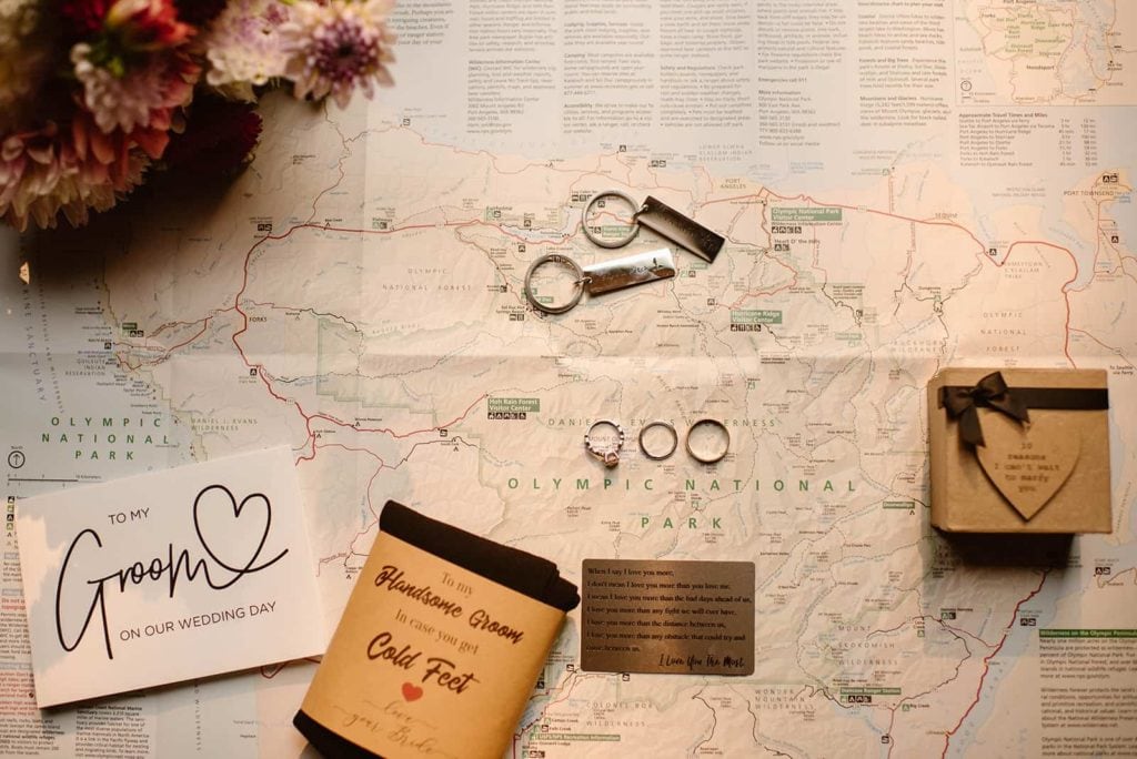 A flat lay of Olympic National Park map with rings and wedding decor.
