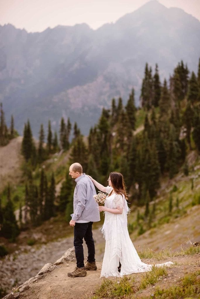 A bride and groom share a first look while out taking in the sunrise at Hurricane ridge with vast mountain views.
