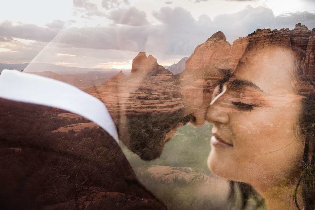 A double exposure image of the bride and groom with a vista of Sedona in the background