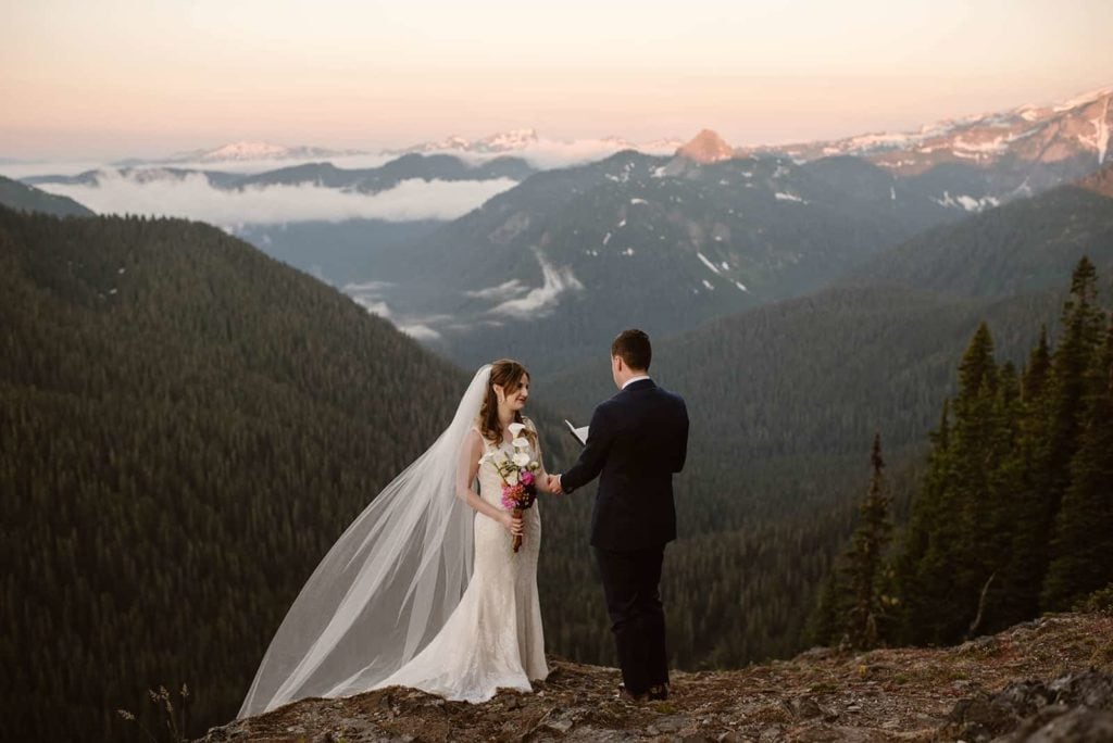 A couple shares their wedding vows together at sunrise in the mountains of washington.
