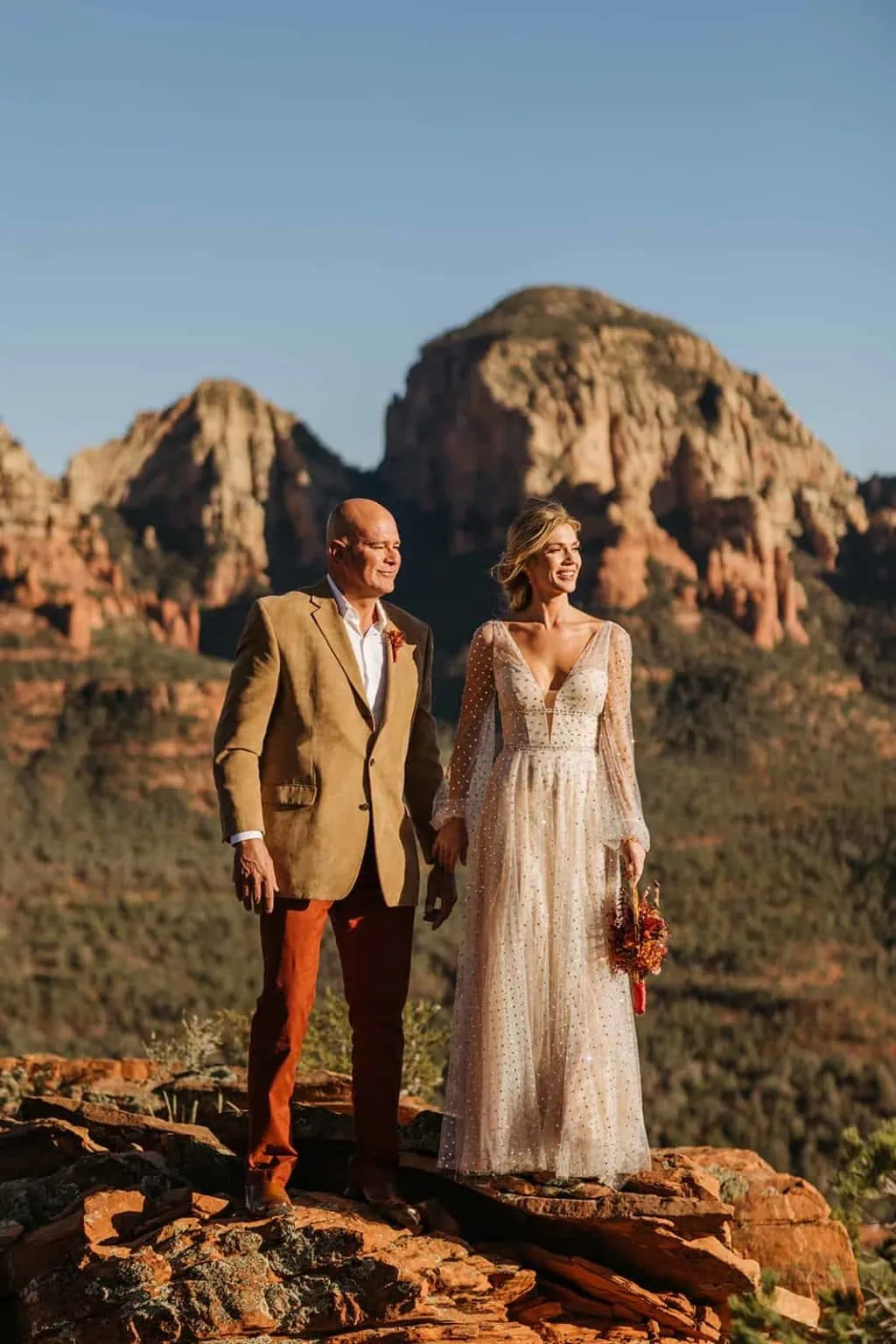 A bride and groom look off into the light in Sedona Arizona.