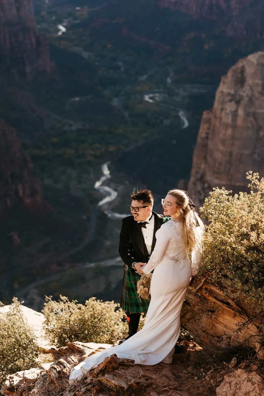 A couple holds hands and take in the canyon views together on their wedding day.