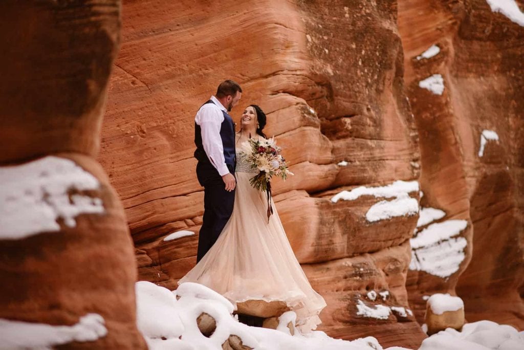 A couple stands in a snowy slot canyon together during their winter elopement.