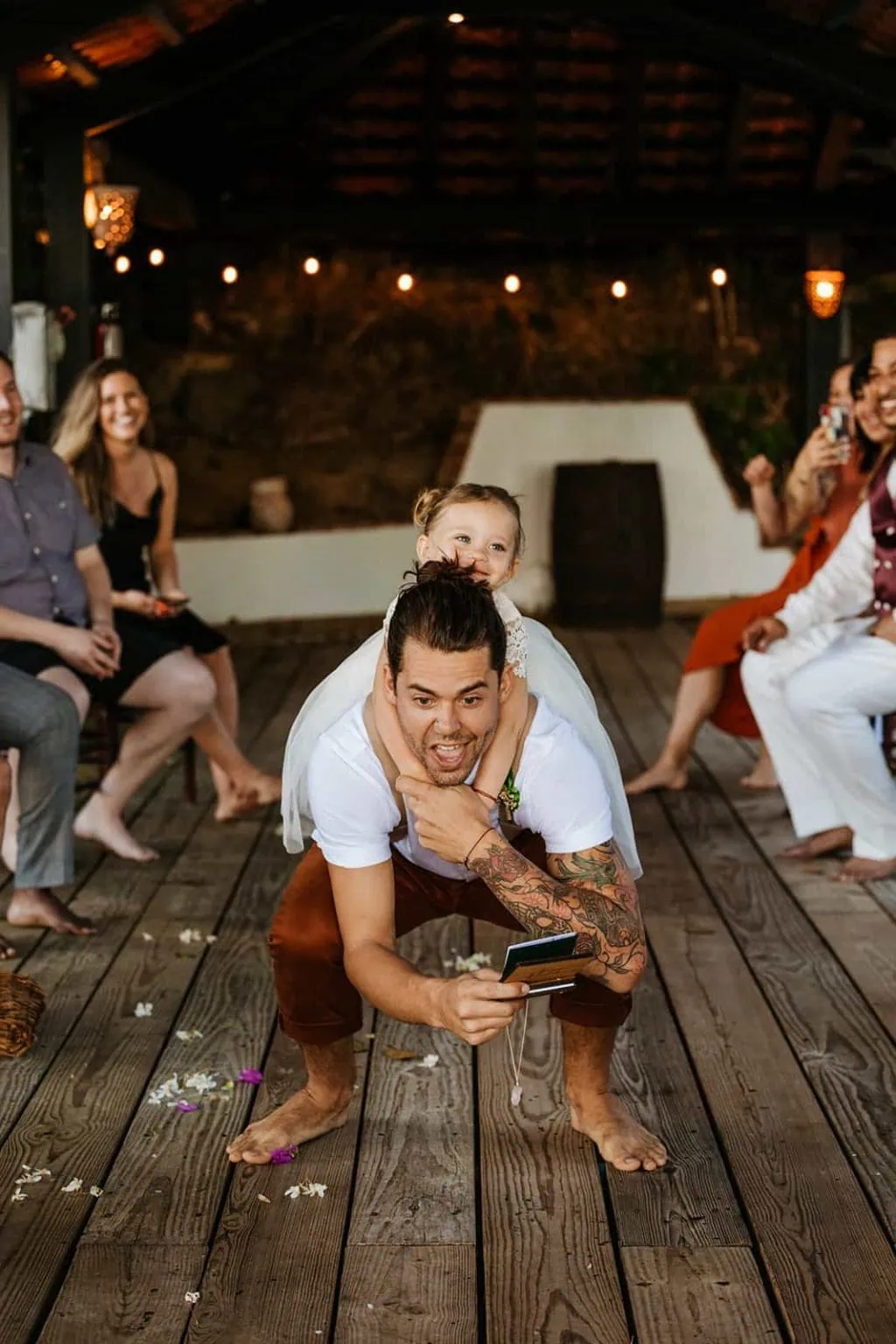 A groom does leap frog with his daughter on his back down the wedding isle.
