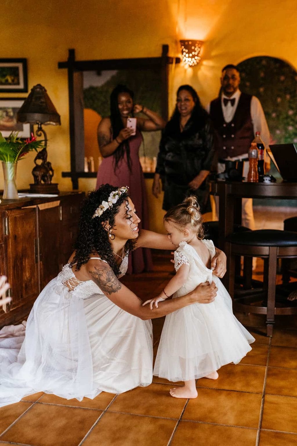 A bride puts a dress on her daughter as they get ready for the wedding.