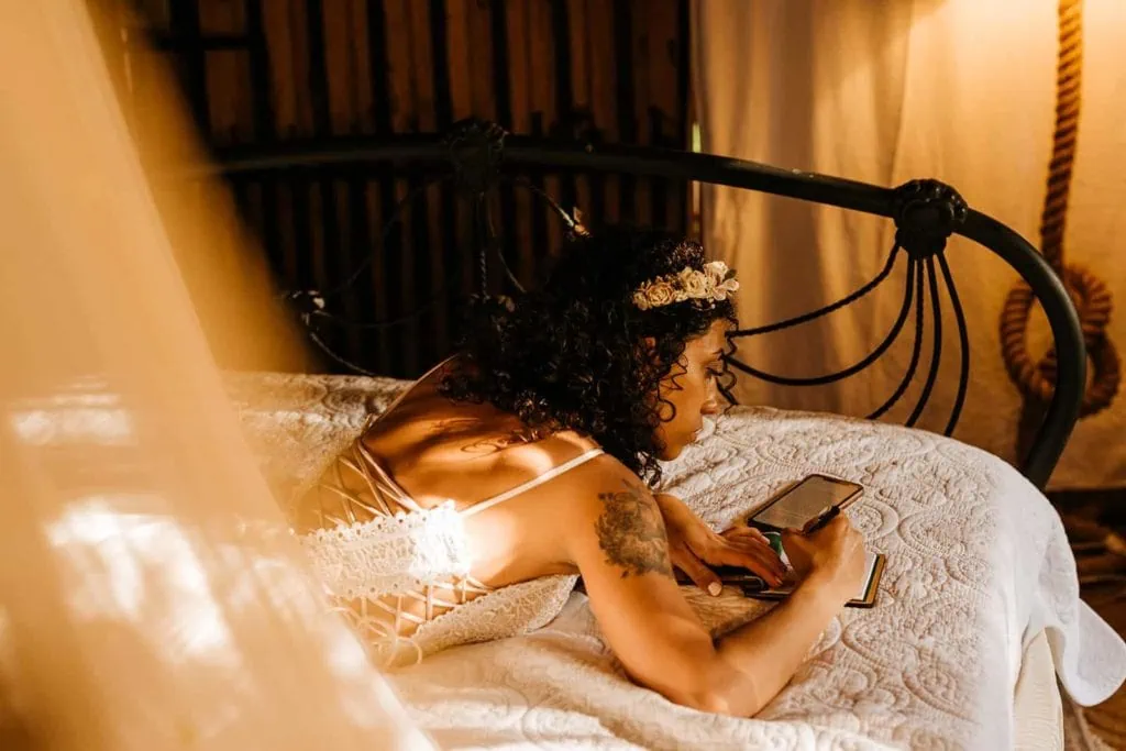 A bride writes her wedding vows as she lays in her wedding dress. 