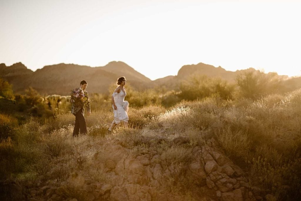 A man and woman walk through the desert together. 