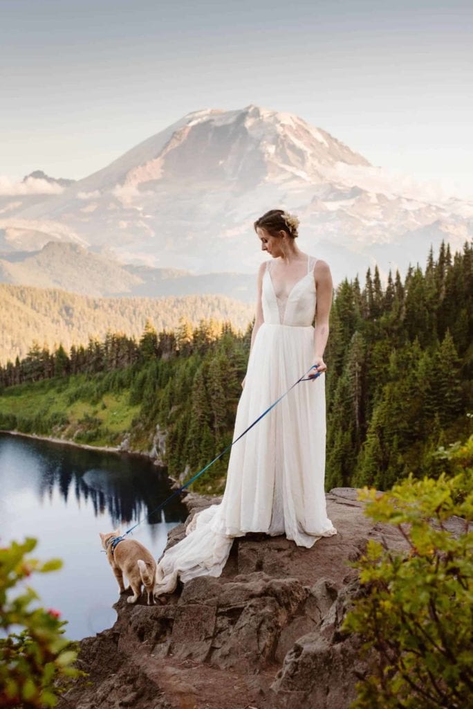 A bride with her cat overlooking a lake.