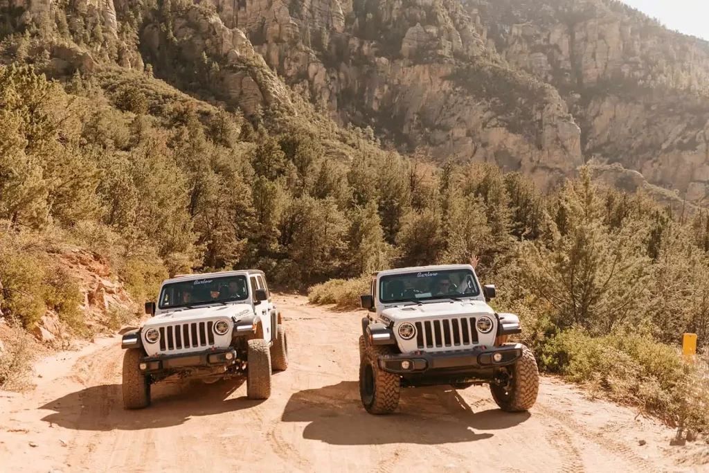 Two jeeps drive up a road together in Sedona