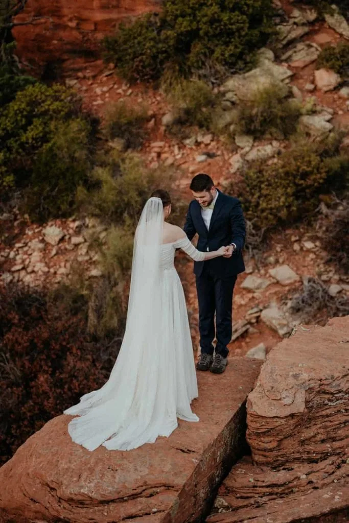 A bride and groom share a first look together on a rock in Sedona.