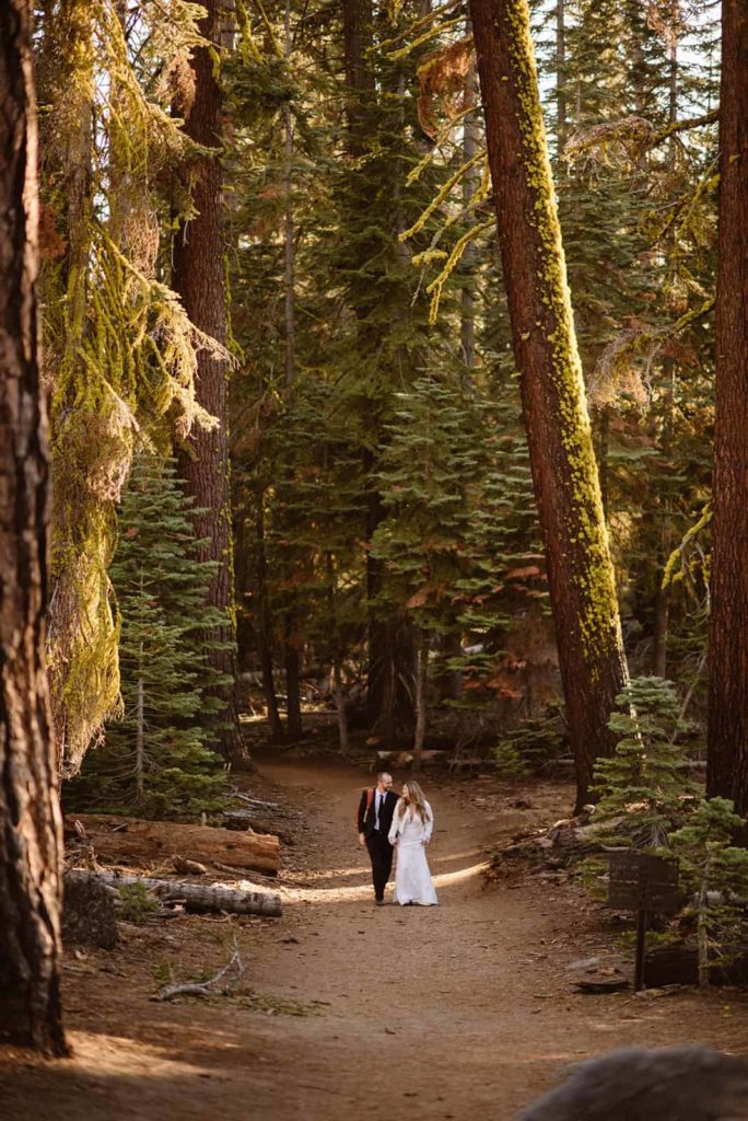 bride and groom walking through the woods of Yosemite.