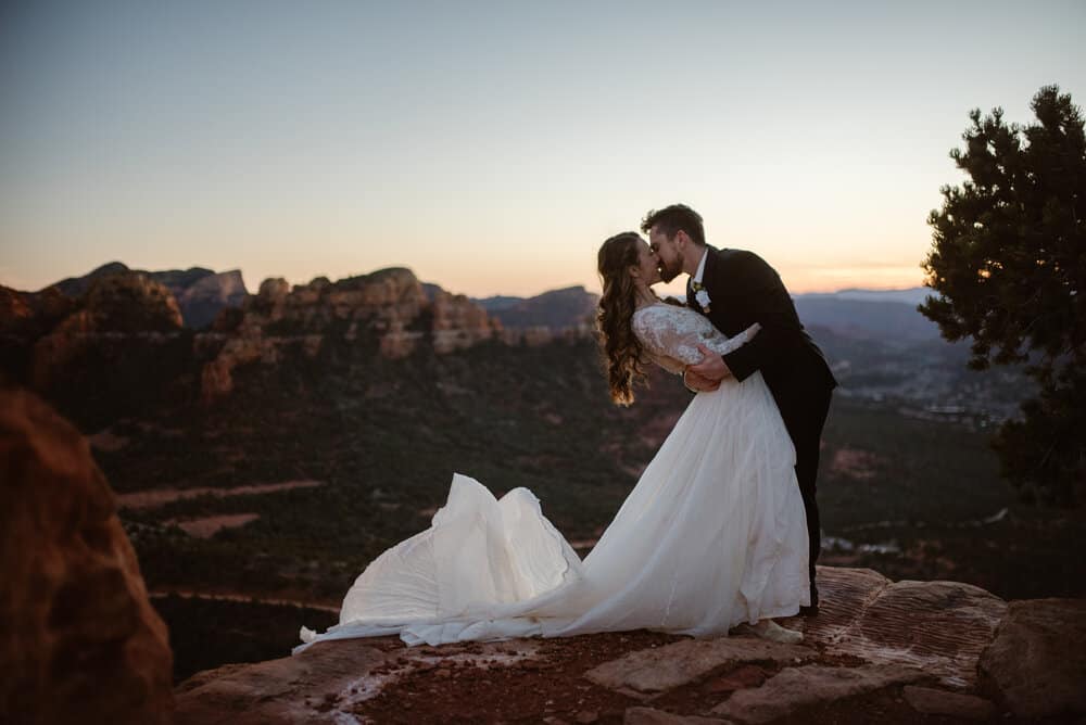 A man stands with his bride durning the final moments of light in Sedona at sunset.