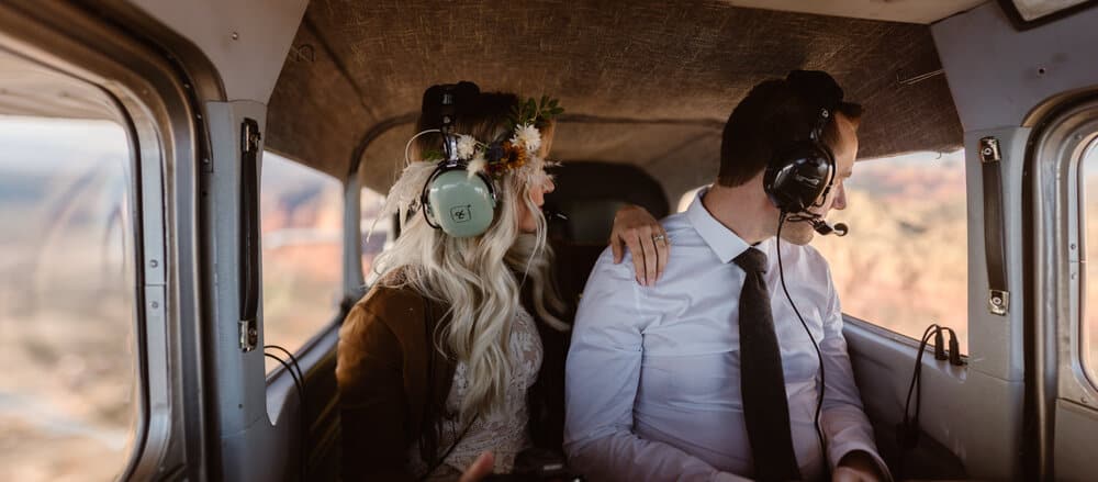 A couple looks at the view outside of the plane during a private ride over canyons in Arizona. 