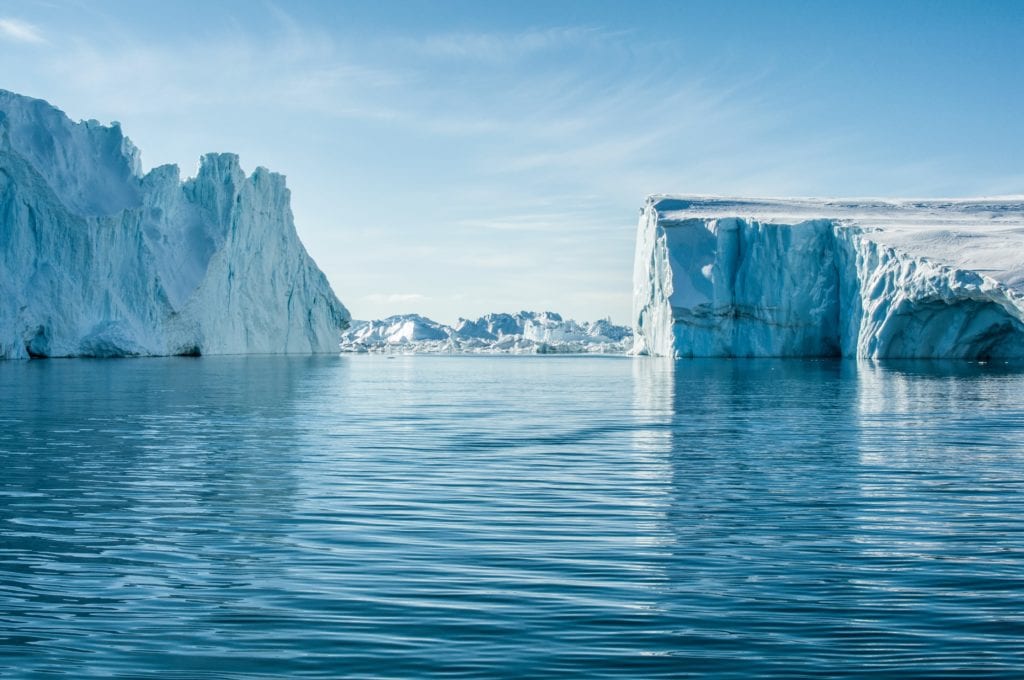 A landscape image of icebergs coming out of the ocean in Greenland.