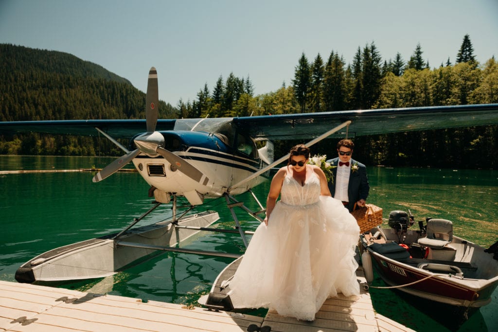 A bride and groom getting off their seaplane together.