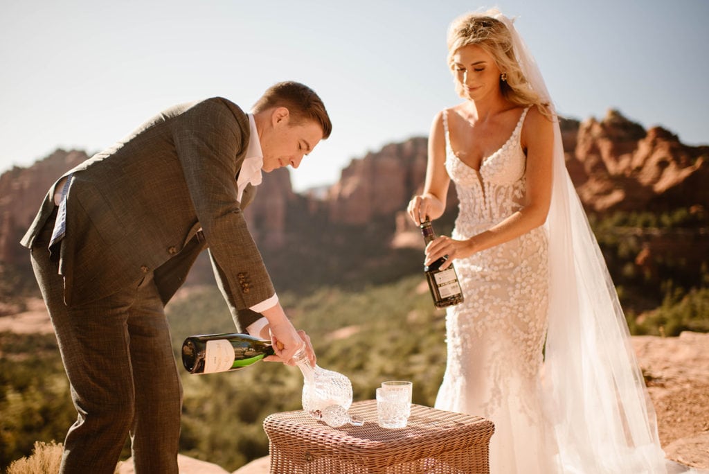 A couple makes a unity cocktail together during their elopement ceremony in the desert on a sunny day.