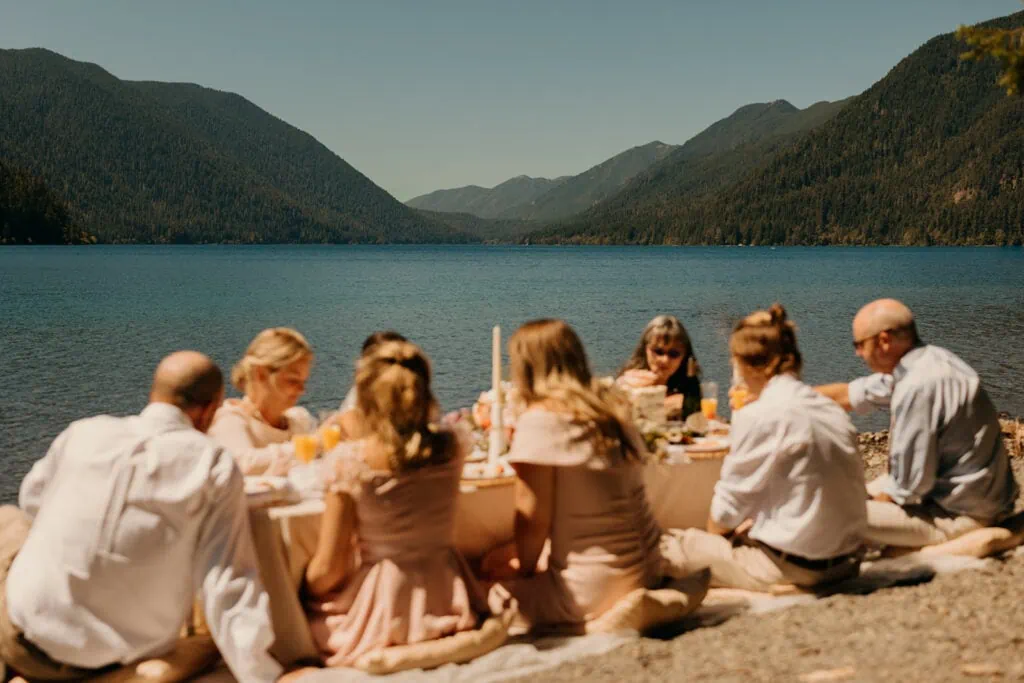 The family sits together at their picnic with an amazing view. 