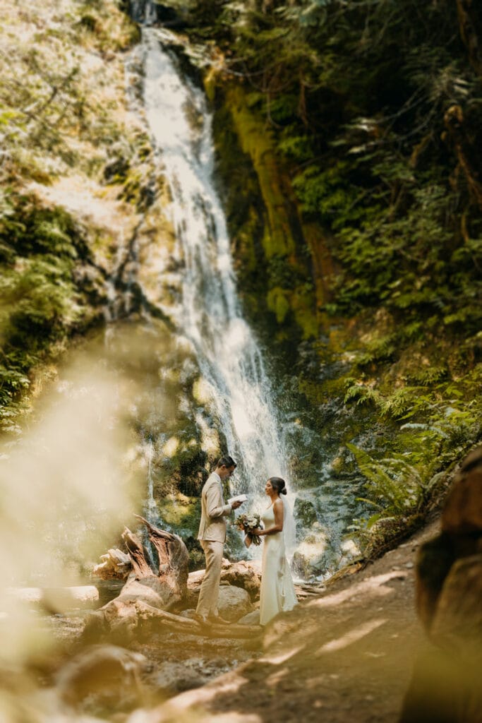 A couple shares private vows at a waterfall during their elopement in Olympic National Park. 