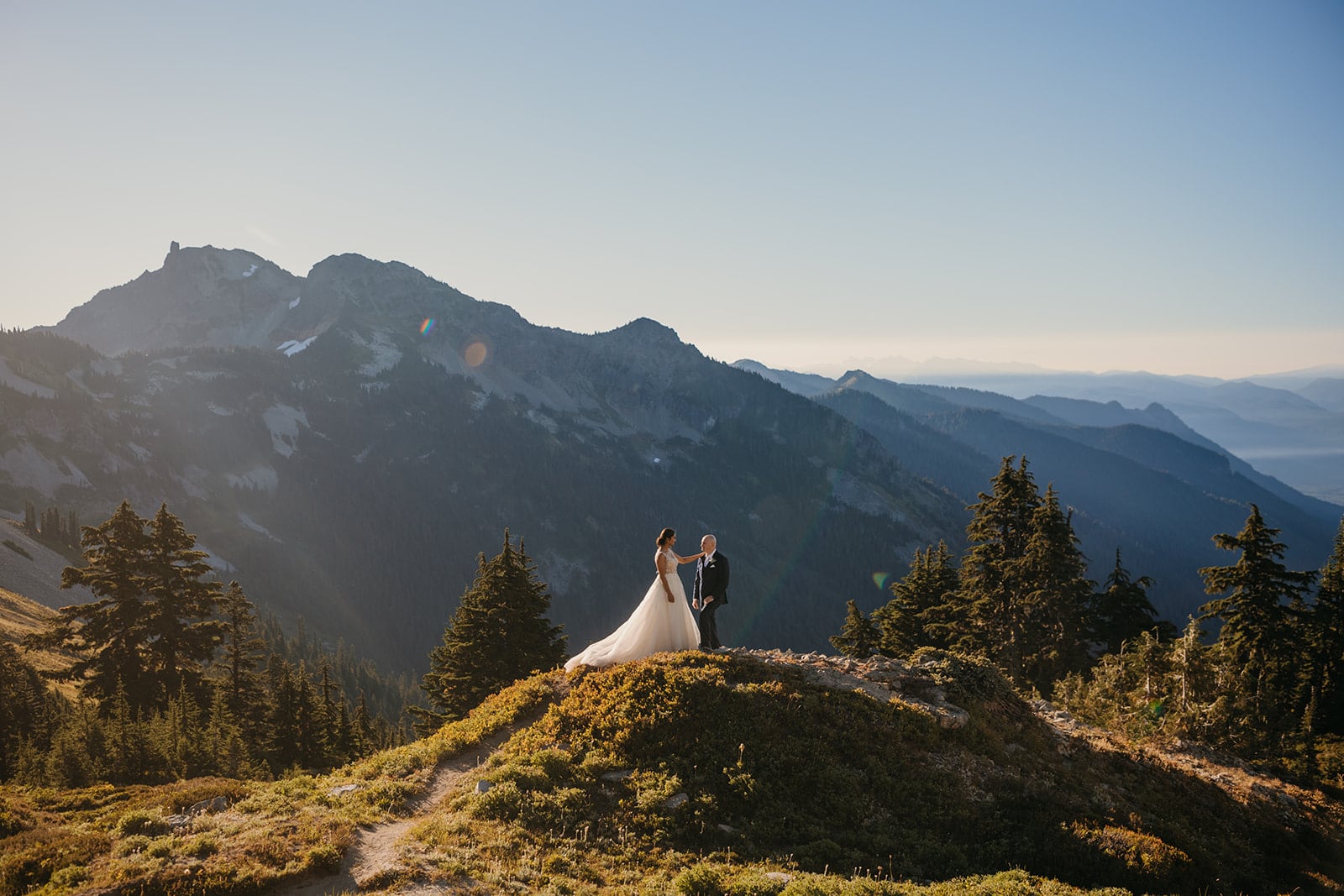 A couple stands together surrounded by mountains on their wedding day in Packwood, WA.