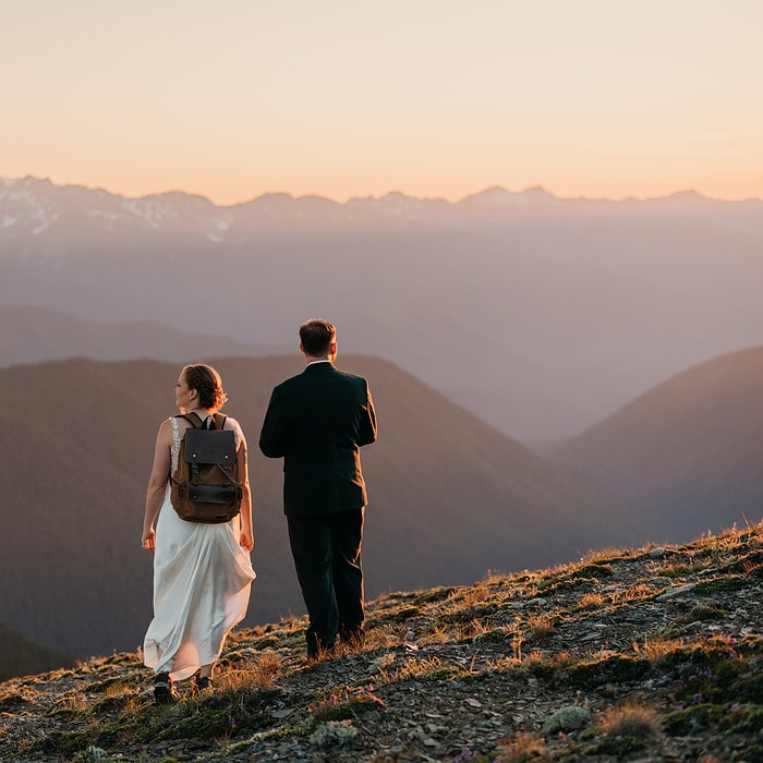 A couple looks out at the mountains during sunset on their elopement day.