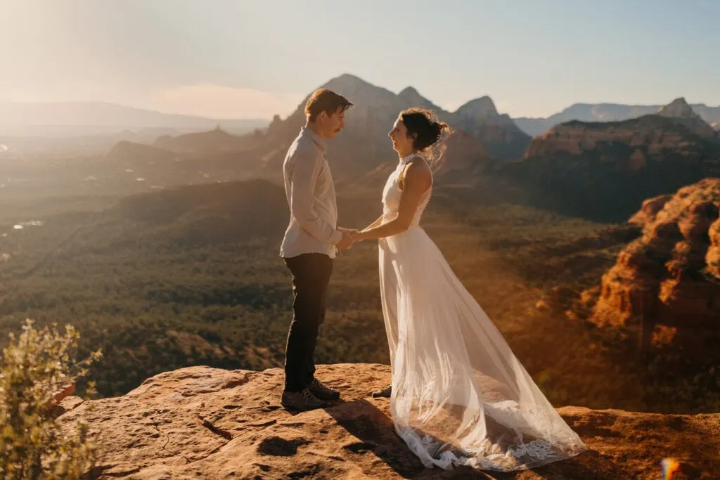 A bride and groom stand together at a beautiful vista in Sedona