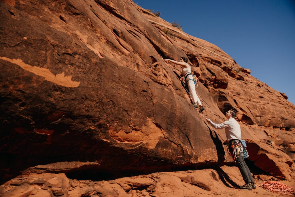 A bride leads up a climbing route on their elopement day.