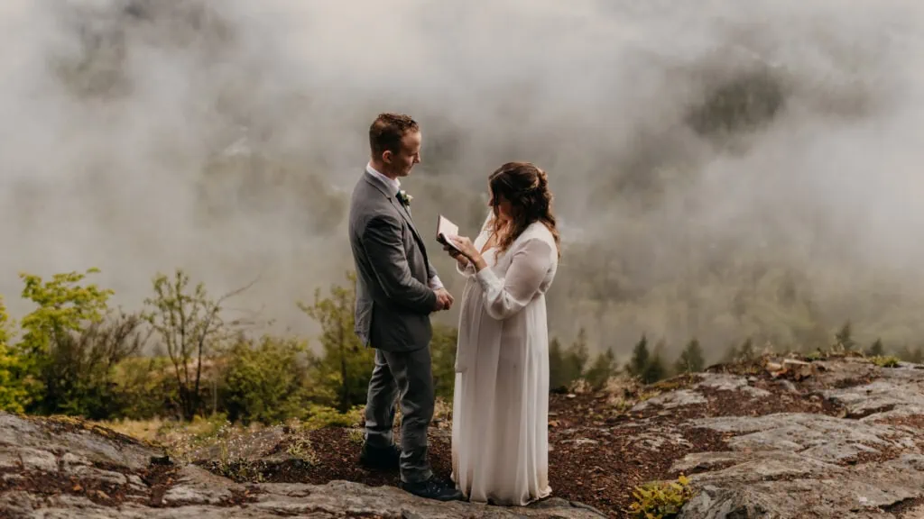 A couple reads their vows together on a moody PNW day.