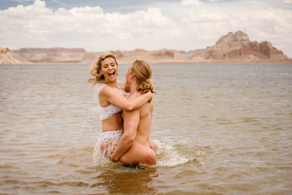 A bride screams as her groom spins her in Lake Powell. 