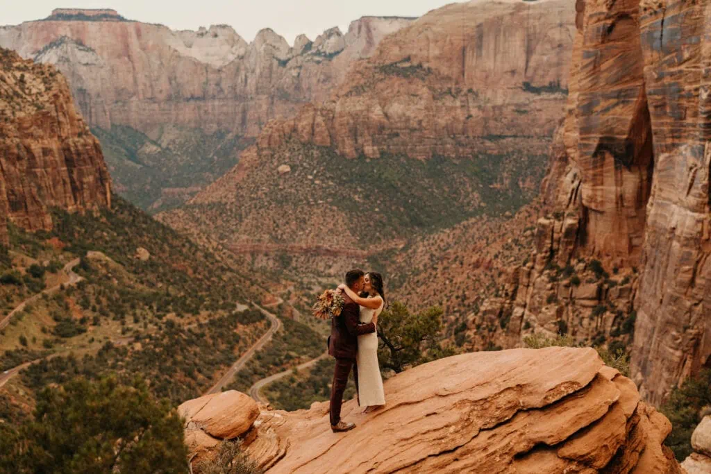 A couple holds each other at sunset at Observation Overlook in Zion National Park.