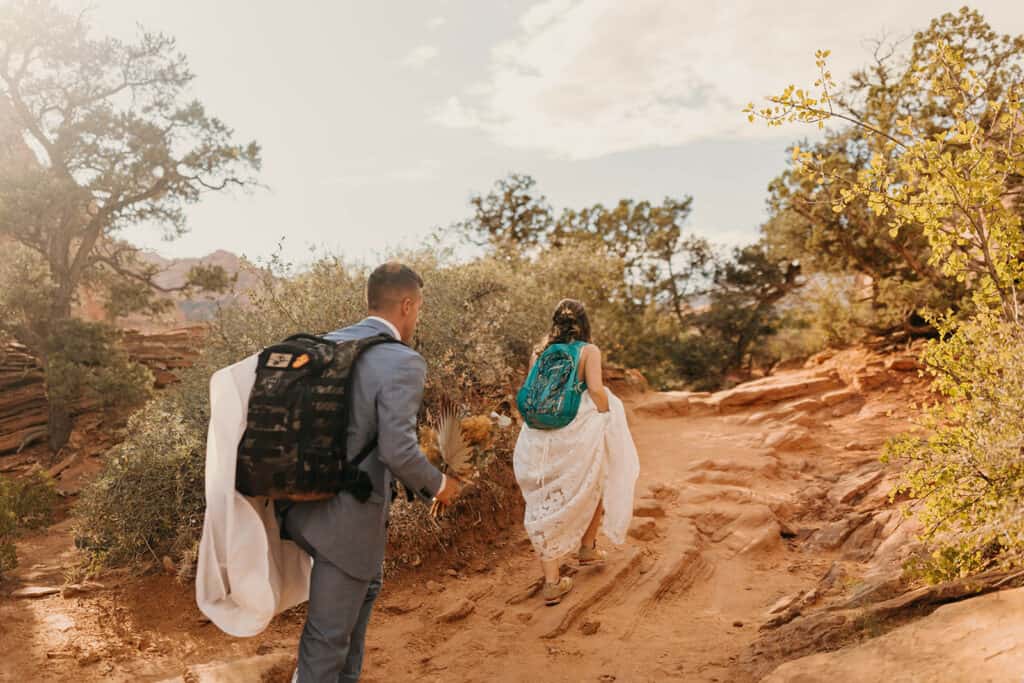 The bride and groom hike together to their elopement ceremony in Zion National Park