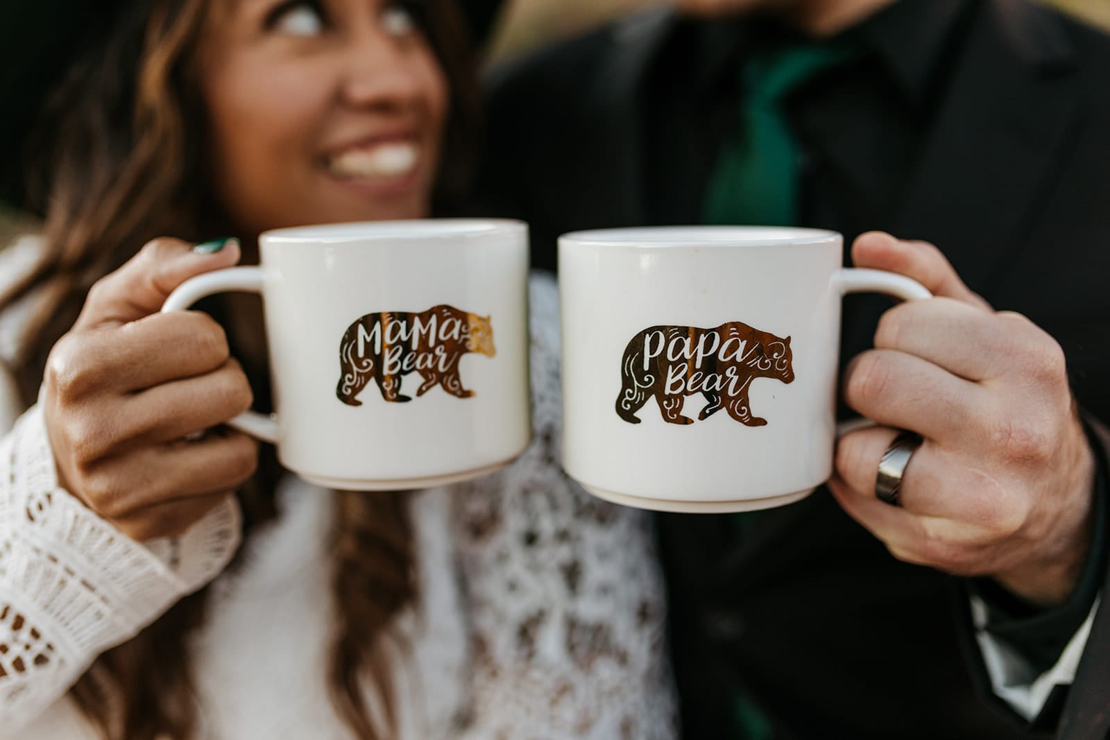 A pregnant bride and groom cheers mugs that say papa bear and mama bear